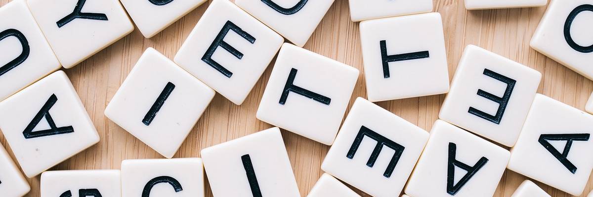 Buchstaben eines Scrabble-Spiels ungeordnet auf einem Tisch liegend