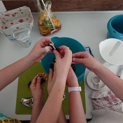 Kinder bröseln Kekse in eine Rührschüssel