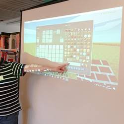 Ein Mitarbeiter des Multimediamobils zeigt die Funktionen von Minecraft auf einer Leinwand