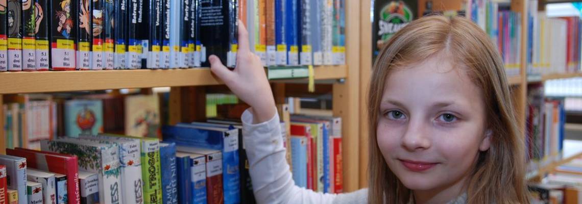 Eine junge Leserin bei der Auswahl eines Buches