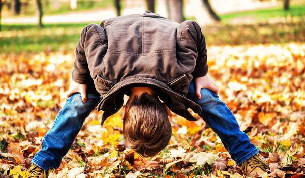 Junge steht auf einer Wiese, auf der Herbstlaub liegt ©Ilka Hanenkamp-Ley